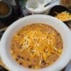 Taco Soup topped with sour cream, cheese and tortilla strips