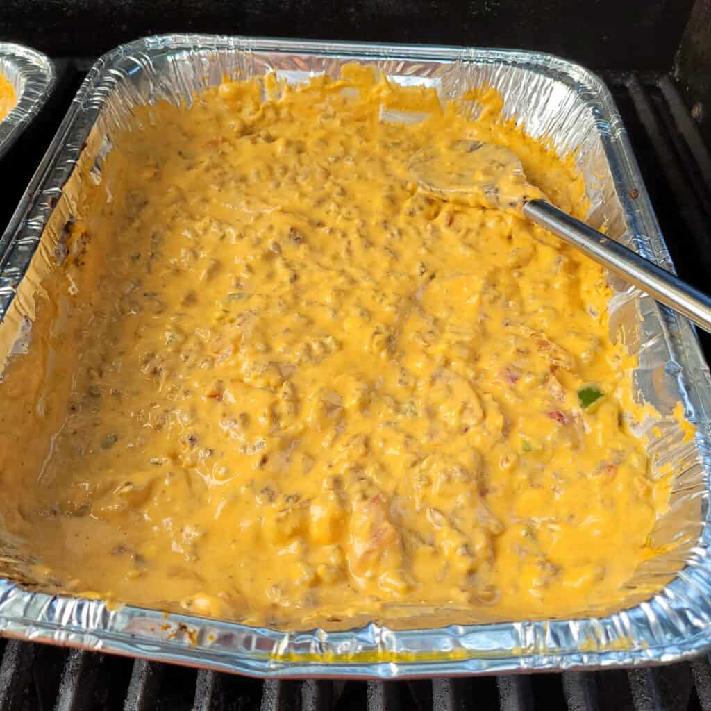 pan of bbq beer cheese queso on the BBQ