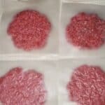 ground beef being shaped into patties in wax paper squares