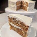 Carrot cake slice in front a cut carrot cake
