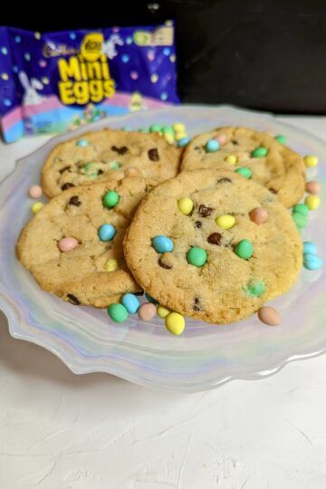 Mini egg cookies on a plate with a bag of Micro Mini Eggs in the background