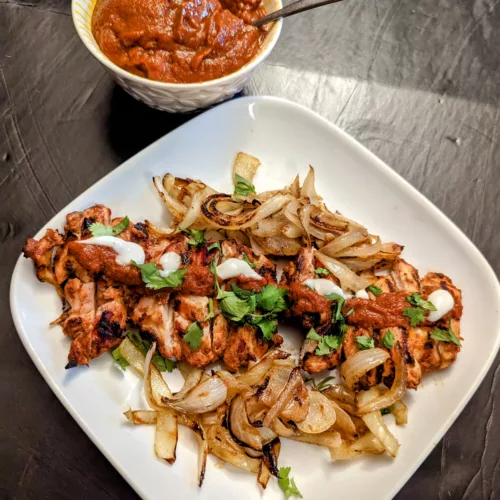 Ancho Chile Chicken with onions and a bowl of Ancho chile sauce