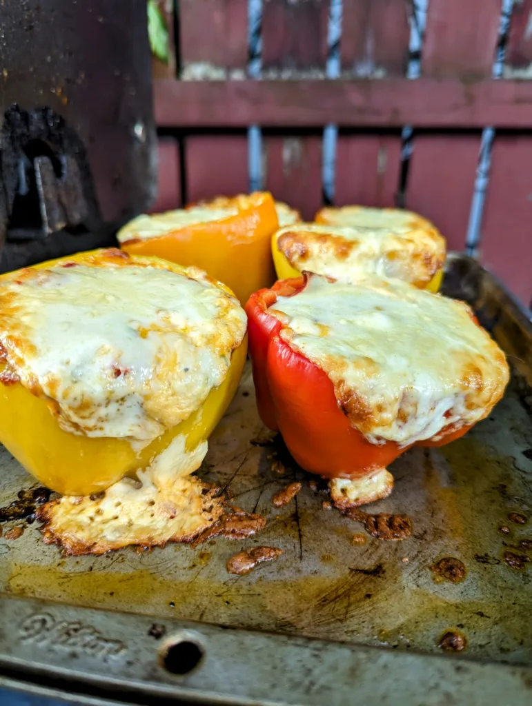 Four Pizza stuffed Bell Peppers on a tray outside