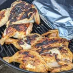 Two spatchcocked chickens on a charcoal bbq